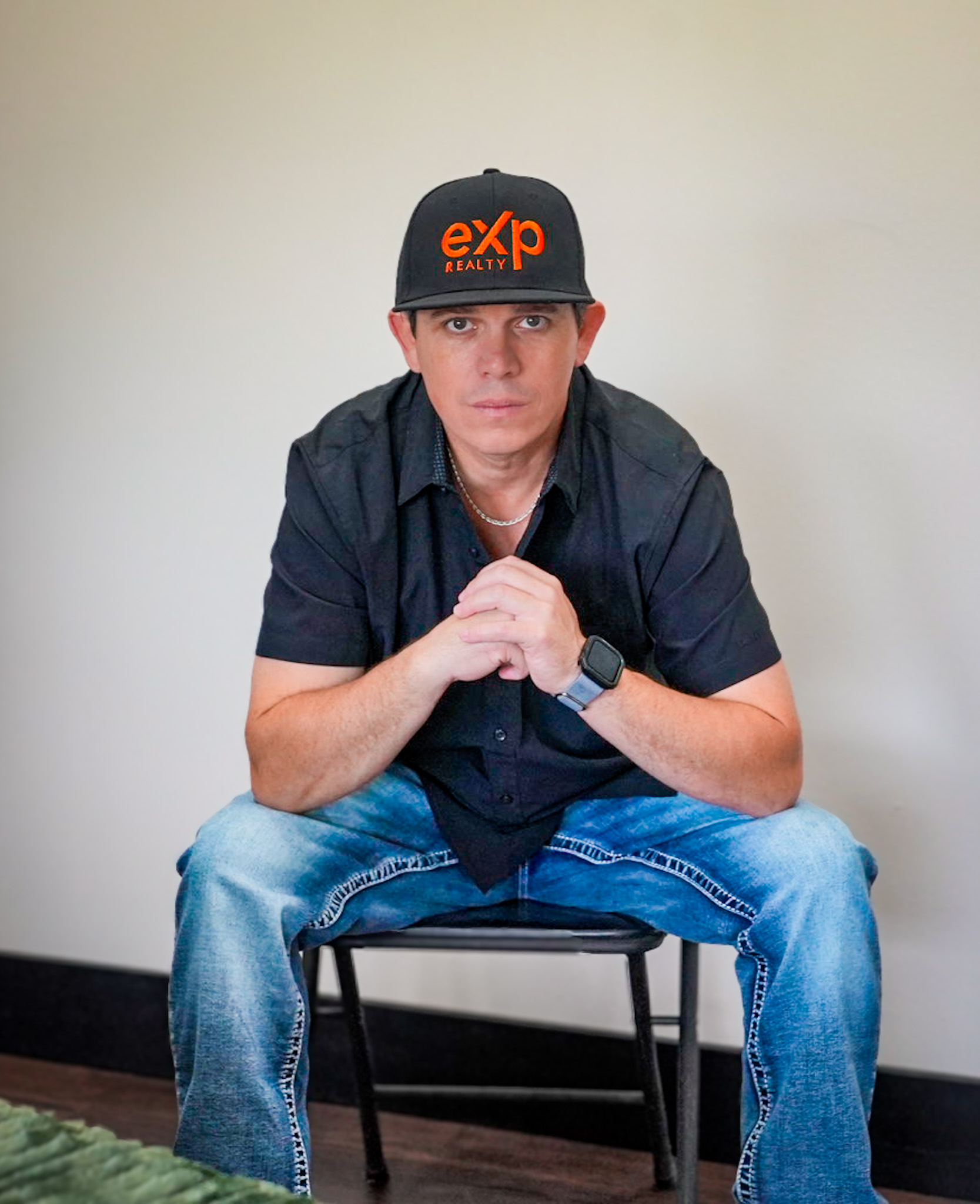 Travis Wright leaning beside a bookshelf in a relaxed professional portrait